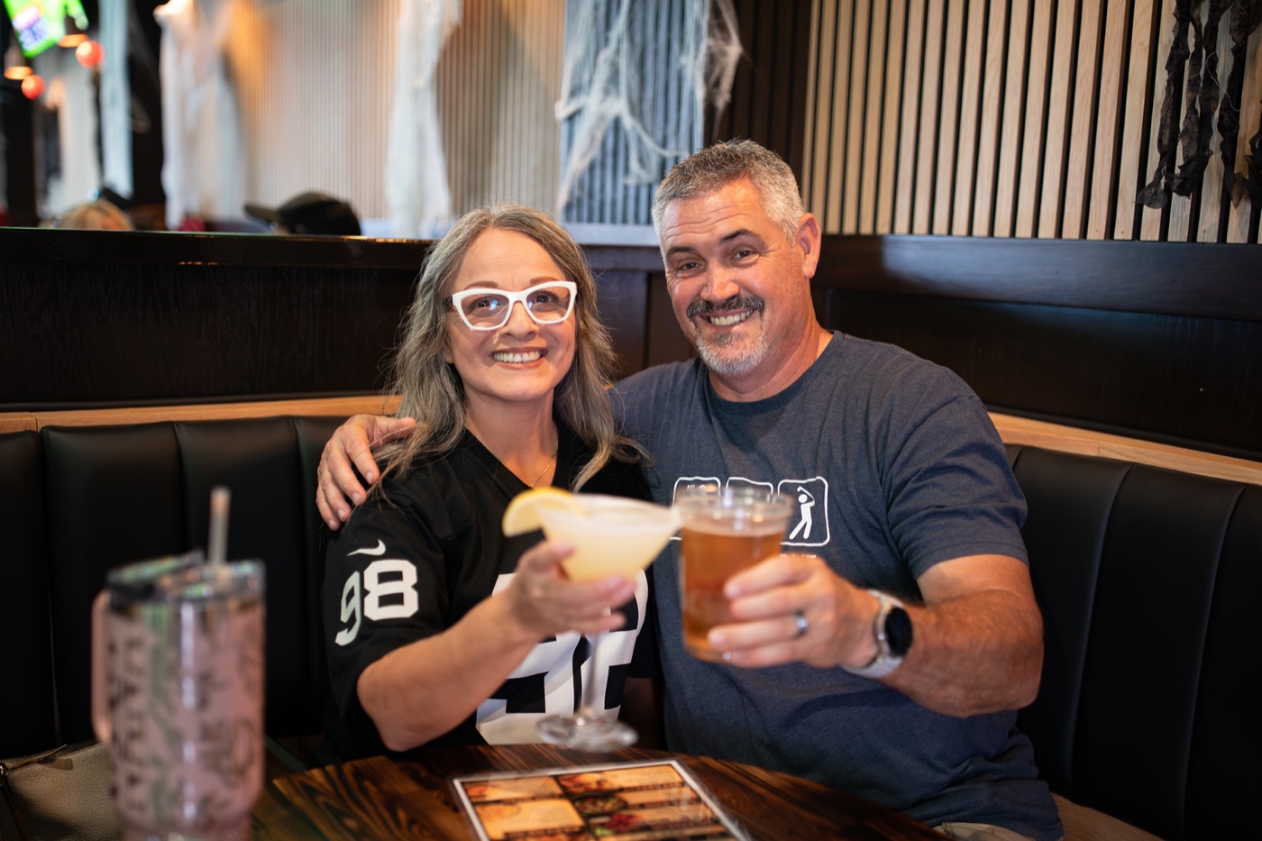 Friends raising their beers on game day at Meganos Well